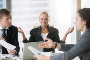 Business negotiation, male partners arguing, funny easygoing woman keeping calm in stressing situation, meditating with composed smile, dealing with emotional angry customer, stress management concept