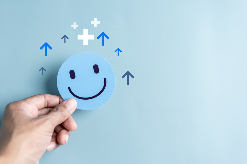 Hands holding blue happy smile face. mental health positive thinking and growth mindset, mental health care recovery to happiness emotion. AdobeStock_668725255